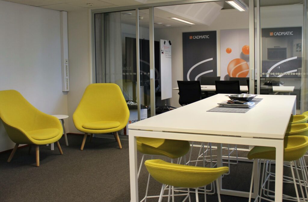 Cadmaticin toimitilamuutos Datariinassa. Kuvassa toimiston aula, jossa limenvihreät tuolit ja korkea keittiönpöytä.